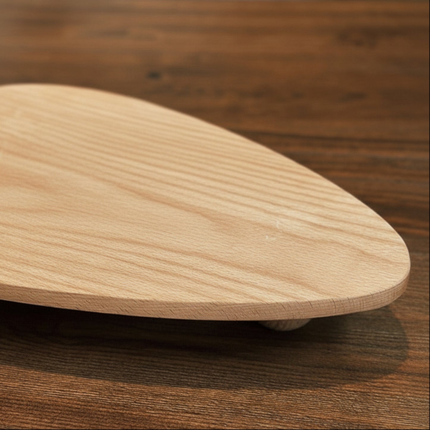 Wooden tray with unique ball high foot design on a wooden surface. Natural and earthy decor item with a irregular triangle shape. 