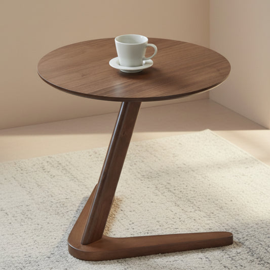Wooden side table with a white cup and saucer on a beige-grey carpet against a beige wall. 