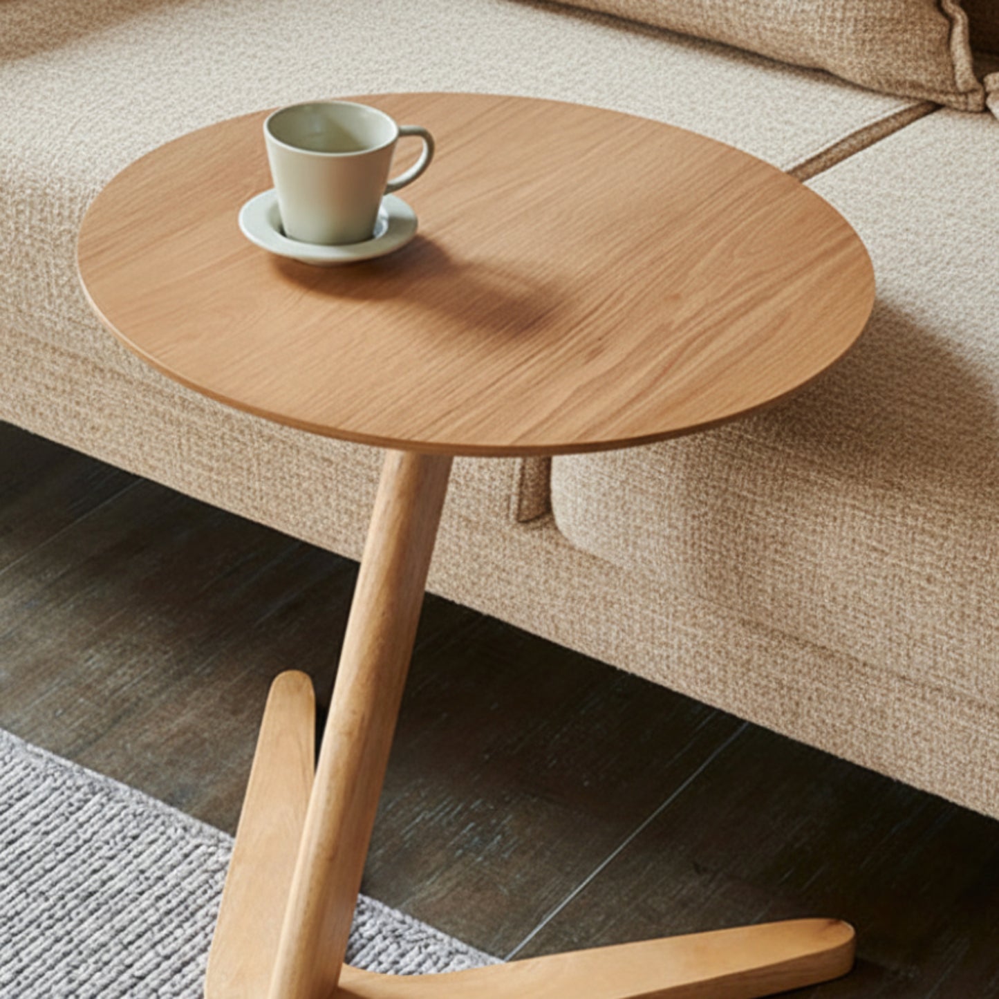 Wooden side table with a cup and saucer on a beige sofa background. Minimalist nordic furniture ambience. 