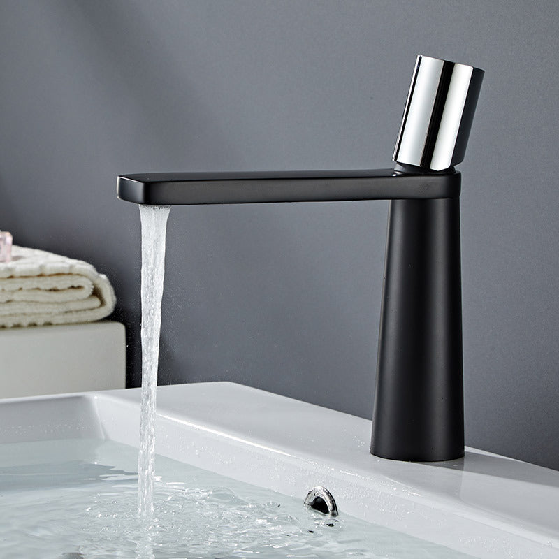 A black and silver basin faucet with a sleek design, displayed against a dark background. Minimalist bathroom or kitchen faucet with premium copper faucet. Timeless design for warm and modern interiors.