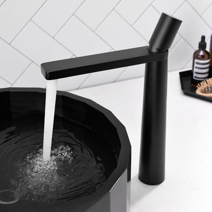 A black colored basin faucet with a sleek design, displayed against a white background and running water.  Minimalist bathroom or kitchen faucet with premium copper faucet. Timeless design for warm and modern interiors.