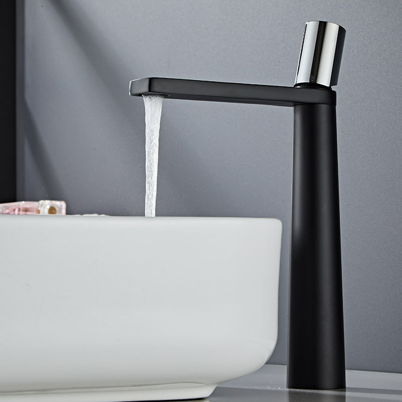 A black-colored basin faucet with a sleek design, displayed against a dark background. Minimalist bathroom or kitchen faucet with premium copper faucet. Timeless design for warm and modern interiors.