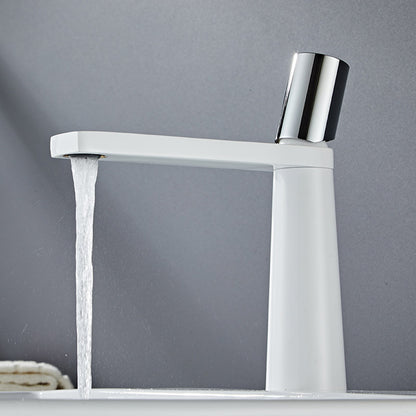 A white colored basin faucet with a sleek design, displayed against a grey background and running water.  Minimalist bathroom or kitchen faucet with premium copper faucet. Timeless design for warm and modern interiors.