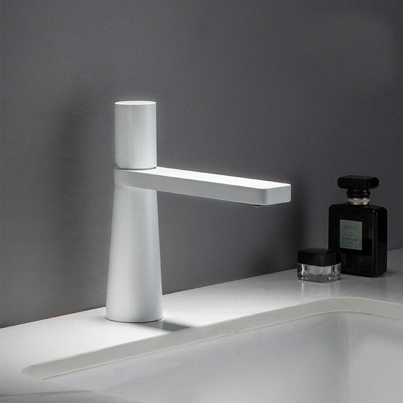 A white colored basin faucet with a sleek design, displayed against a grey background.  Minimalist bathroom or kitchen faucet with premium copper faucet. Timeless design for warm and modern interiors.