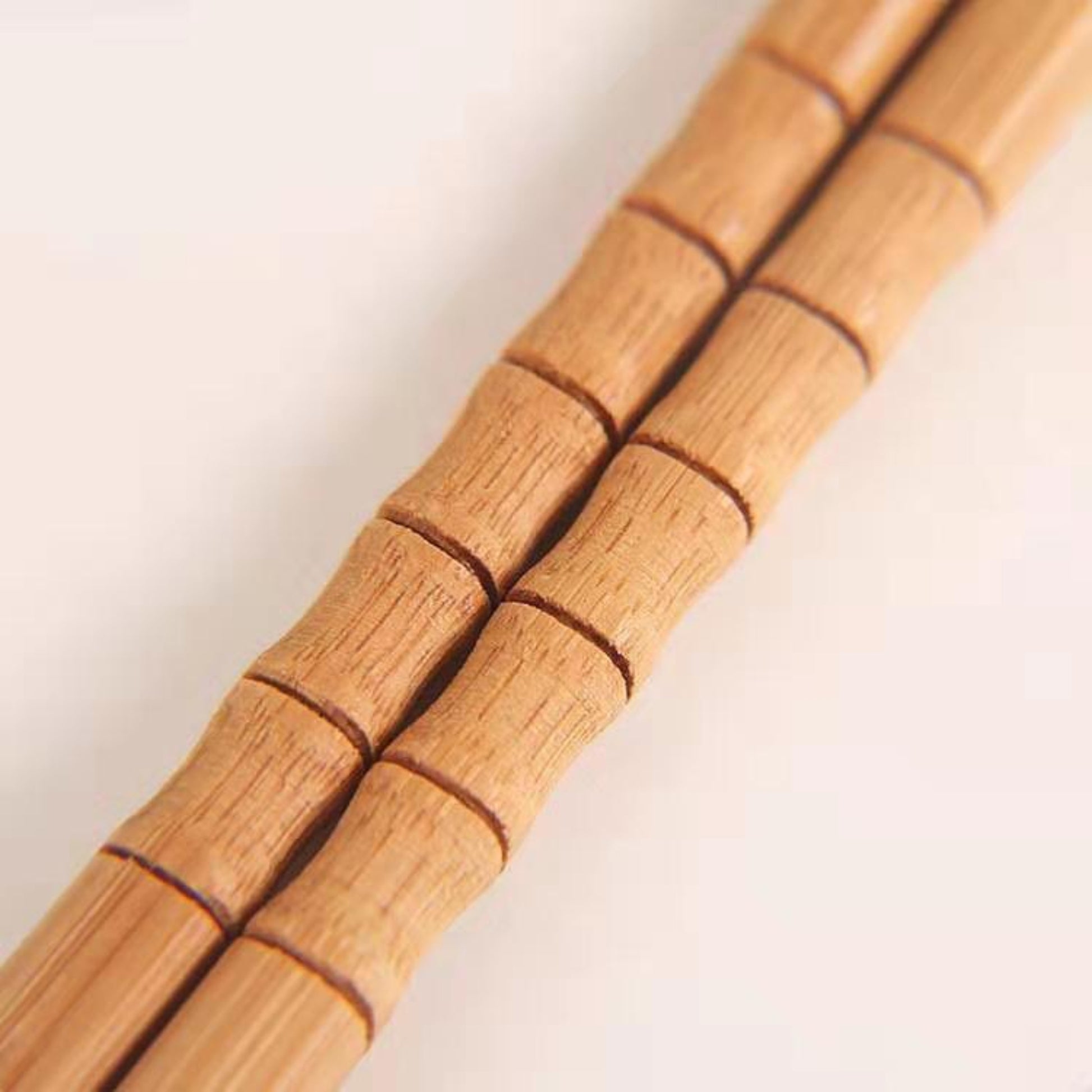 Close-up of one pair of chopsticks on a white surface. Natural, unpainted, eco-friendly bamboo. 