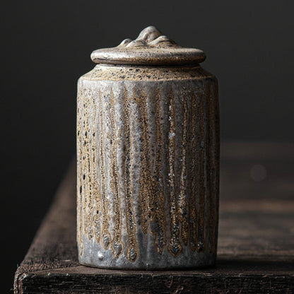 Dark and hand trimmed ceramic jar with lid on a dark wooden surface, with a dark background. Stylish kitchen decor. Modern and traditional. Timeless piece.