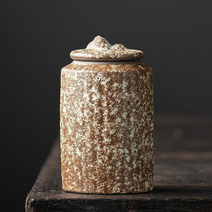Rustic ceramic jar with a textured surface on a dark background. Rusic and hand trimmed ceramic jar with lid on a dark wooden surface, with a dark background. Stylish kitchen decor. Modern and traditional. Timeless piece.