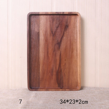 A collection of square and rectangular walnut wooden plates in various sizes, with a hand-painted texture, displayed on a beige background. Earthy tones and whole wood. Calm and minimalist interior atmosphere.