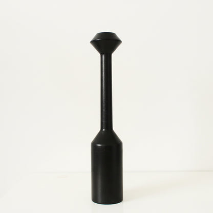 Black cylindrical large wooden candle holder with a conical top on a white background. Earthy and natural home decor. 